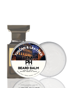 Beard balm container with 'Tuscan & Leather' scent on a white background